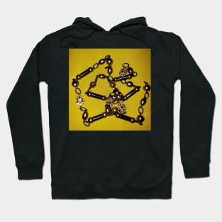 Pearls, black beads, and chains, on a deep yellow background Hoodie